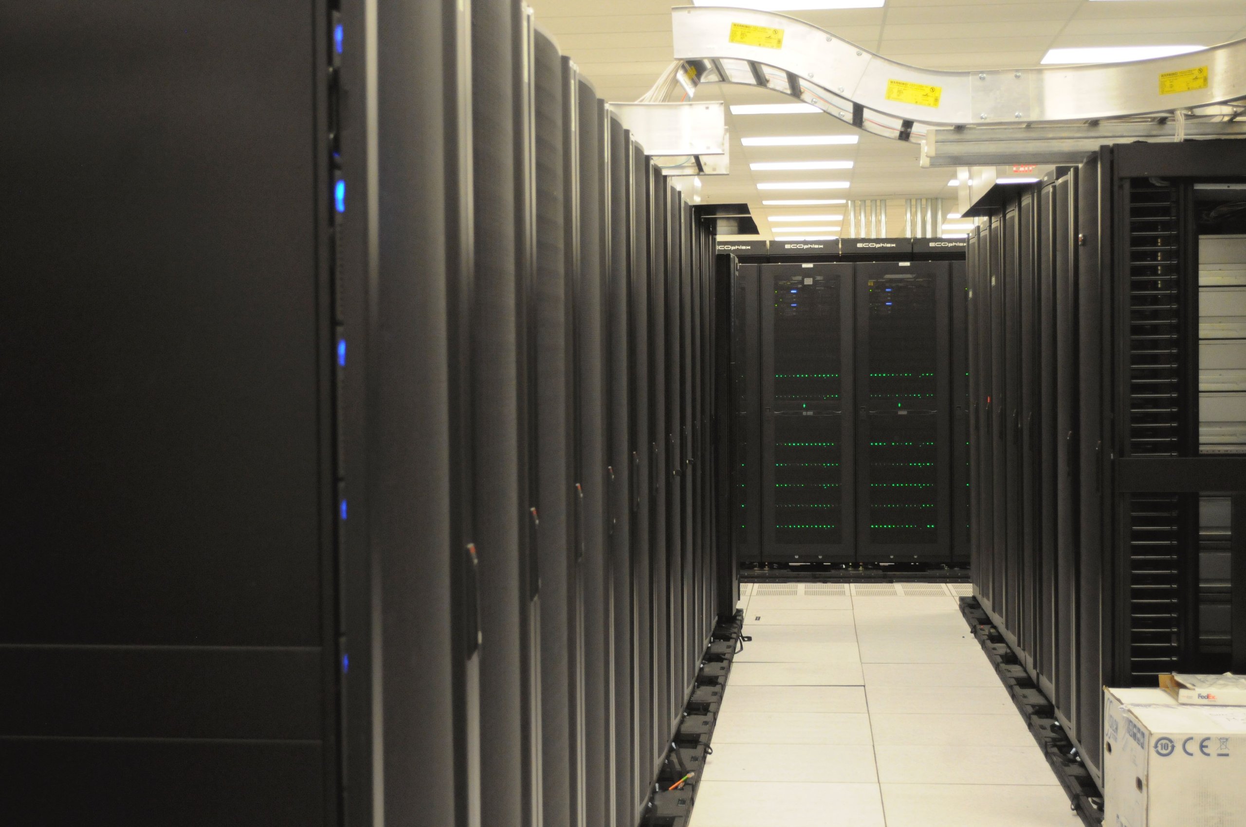 Long aisle of black server racks in a data center